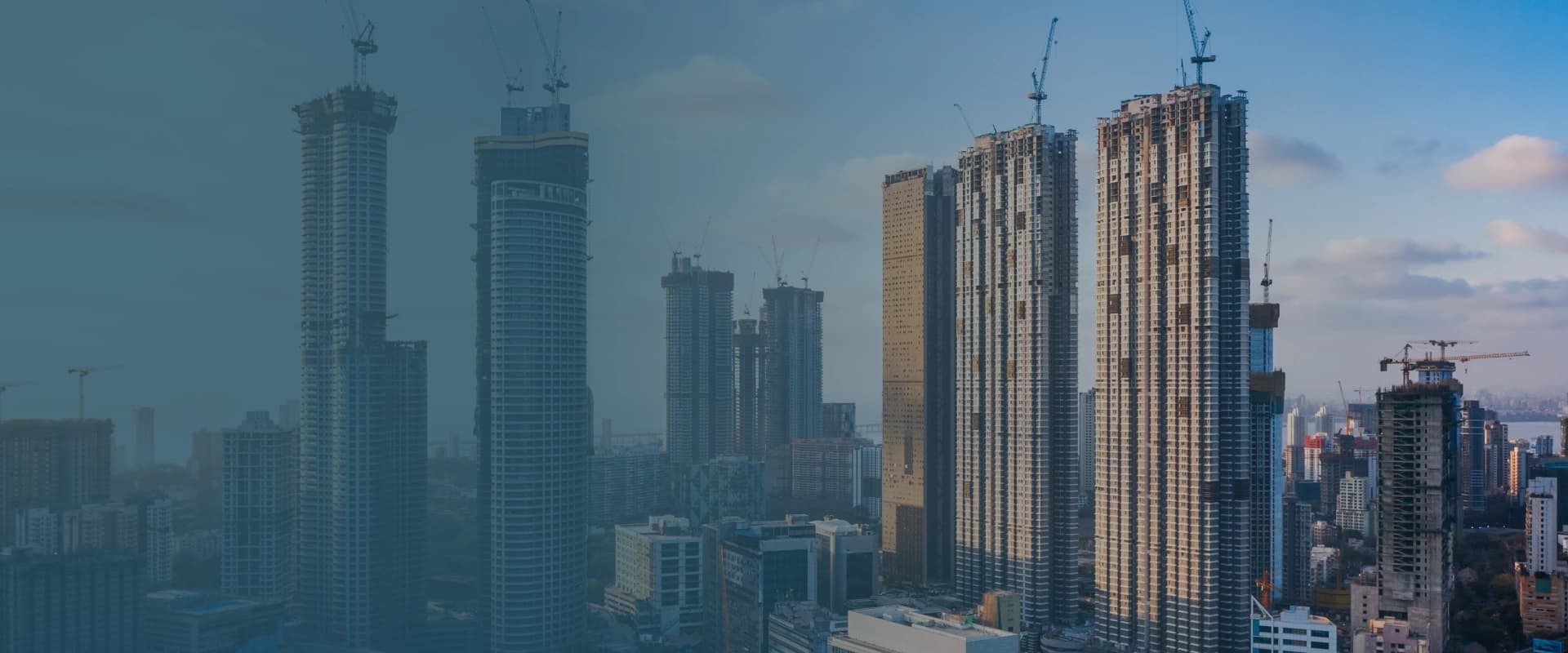City skyline with high-rise buildings and construction cranes — Dhenu Buildcon