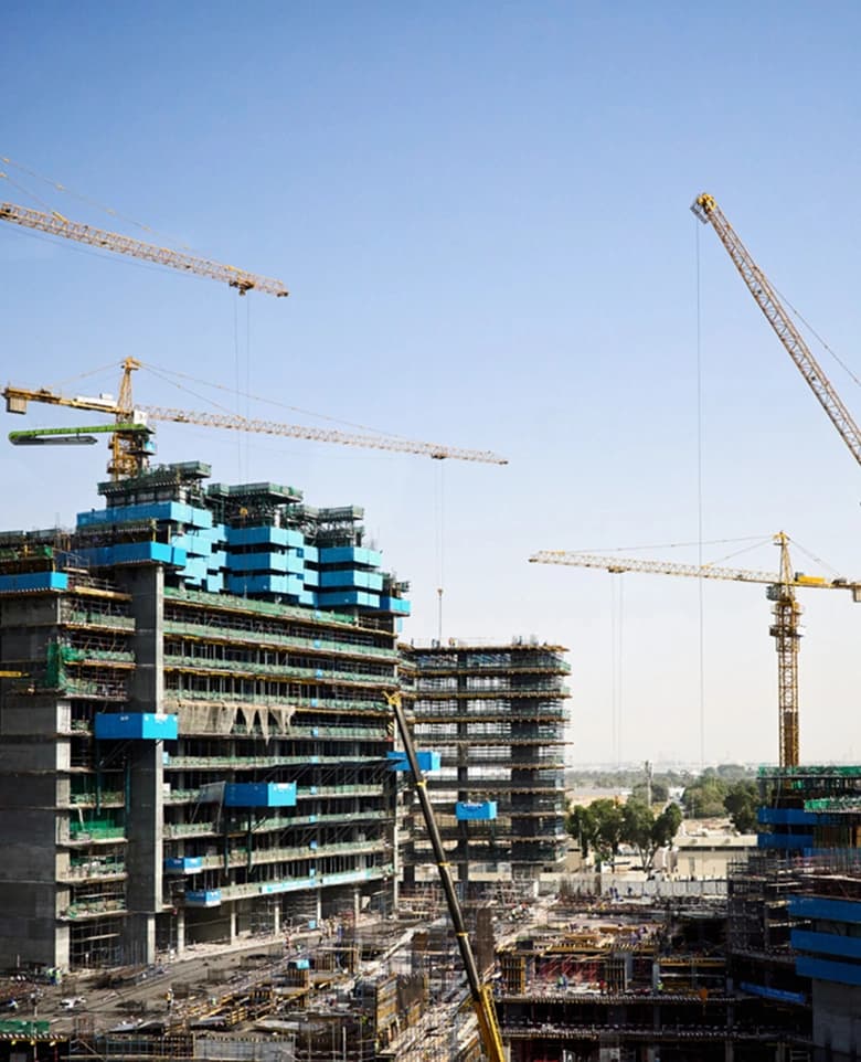 High-rise construction site with cranes and safety netting